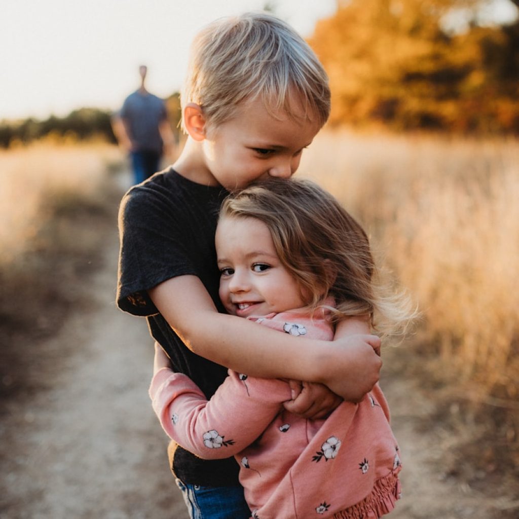 boy in black t-shirt hugging girl in red and white polka dot dress